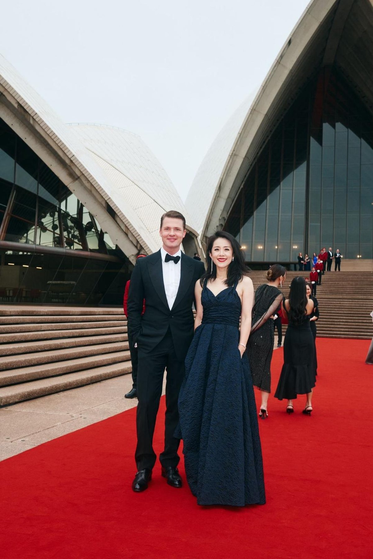 James Sackl and his wife Alina Sackl on the red carpet at the Sydney Opera House for the Cartier gala, June 2026 — James in a black tuxedo and bow tie, Alina in a navy gown, the sails of the Opera House behind them.