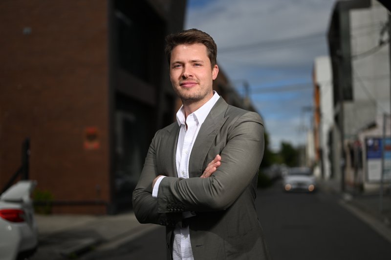 James Sackl, Australian founder, in a Melbourne back-street portrait, grey blazer and half-smile.