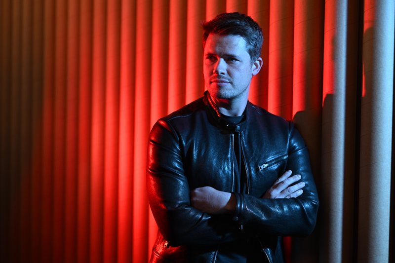 James Sackl, Australian founder and writer, in a Melbourne studio portrait — black leather jacket, looking off-camera.
